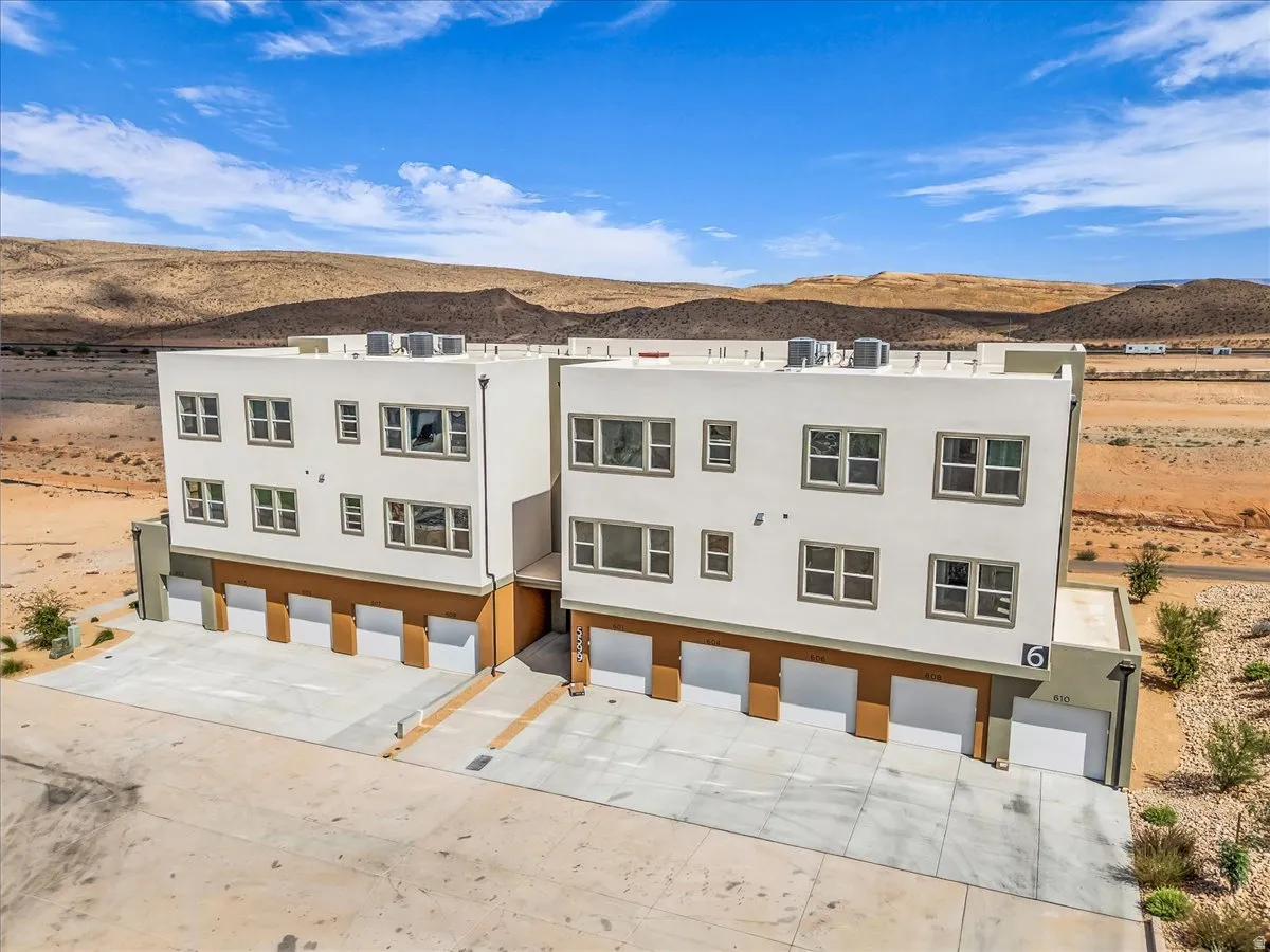 Multi-story stucco exterior with multiple windows and integrated garage bays