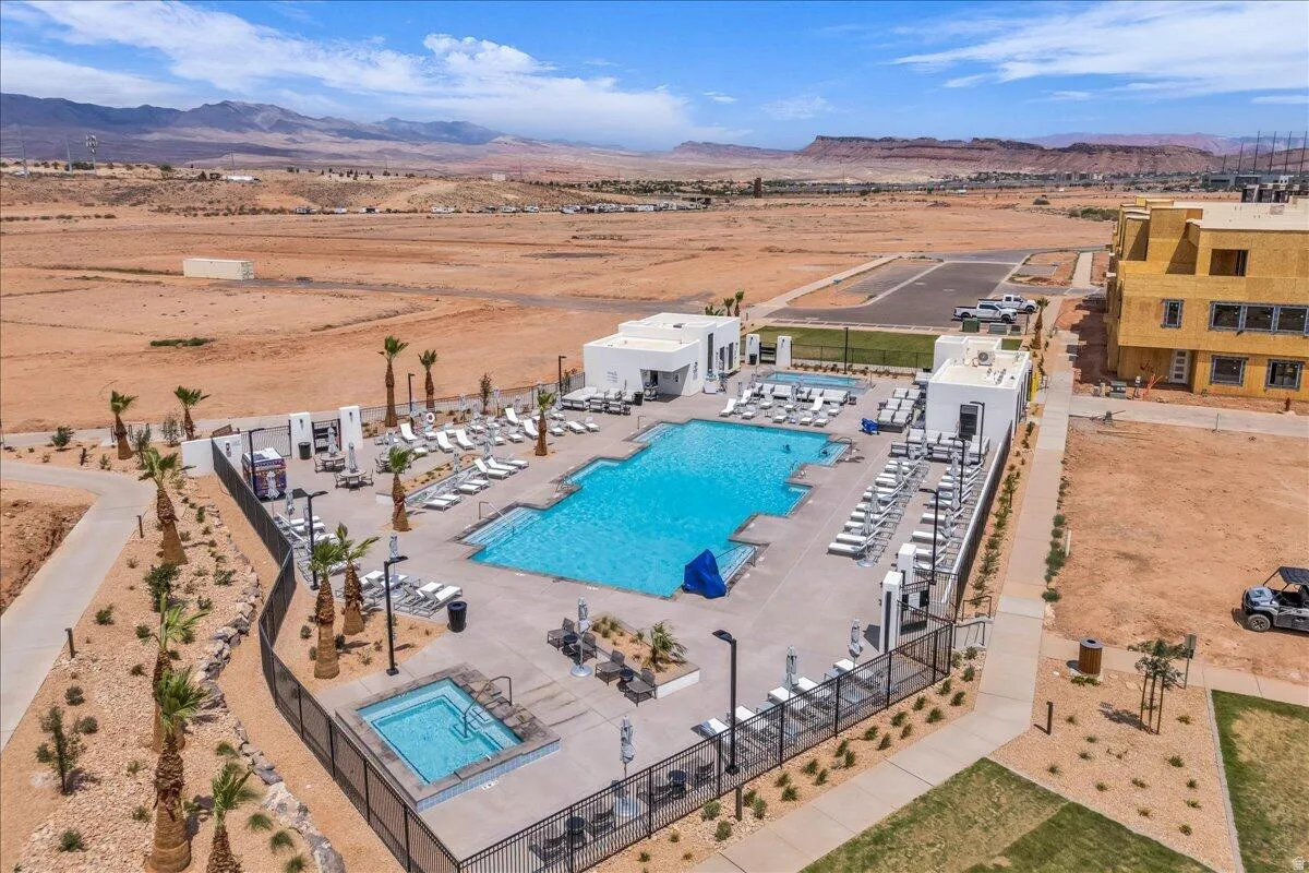 Expansive outdoor pool area with integrated spa, surrounded by desert landscaping and modern architecture