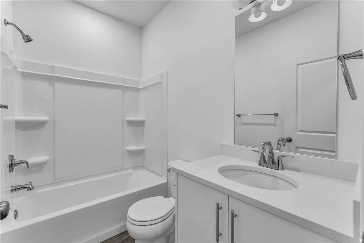 White vanity with a light-toned countertop, oval undermount sink, and chrome faucet