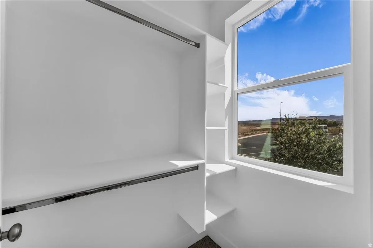 Built-in closet shelving, integrated hanging rods, and a large window