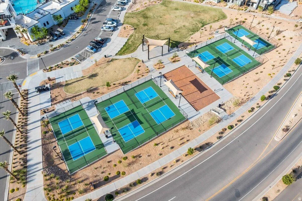 Expansive recreational facility featuring multiple professional-grade tennis and pickleball courts with hard court surfaces in vibrant blue and green