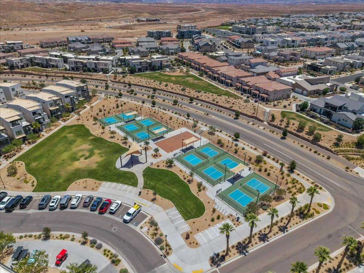 Community green space with multiple recreational courts, manicured lawn areas, and shade structures