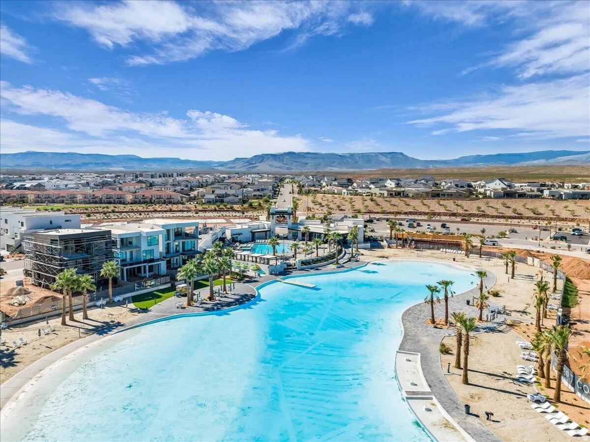Expansive lagoon with a paved perimeter, surrounding sand-finish areas, and mature palm trees