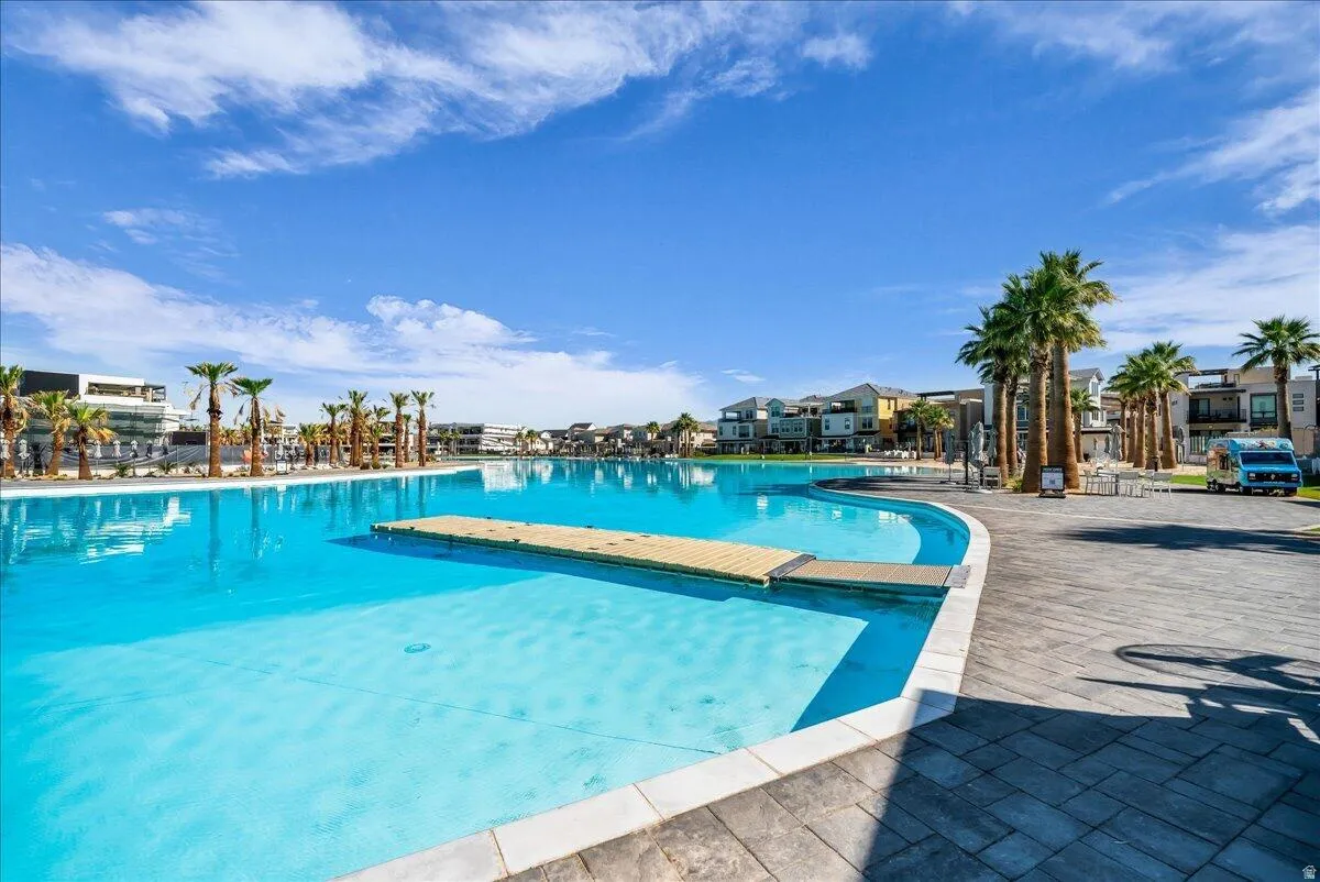 Expansive lagoon-style pool with a floating dock and paved surround