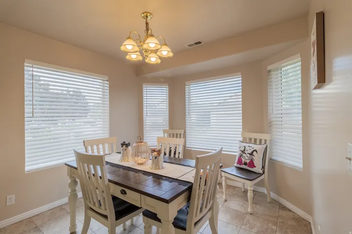 Bay window feature with multiple windows, overhead chandelier, and tile flooring