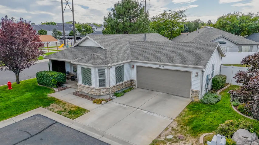 Siding exterior with stone veneer accents, an attached garage, and a concrete driveway
