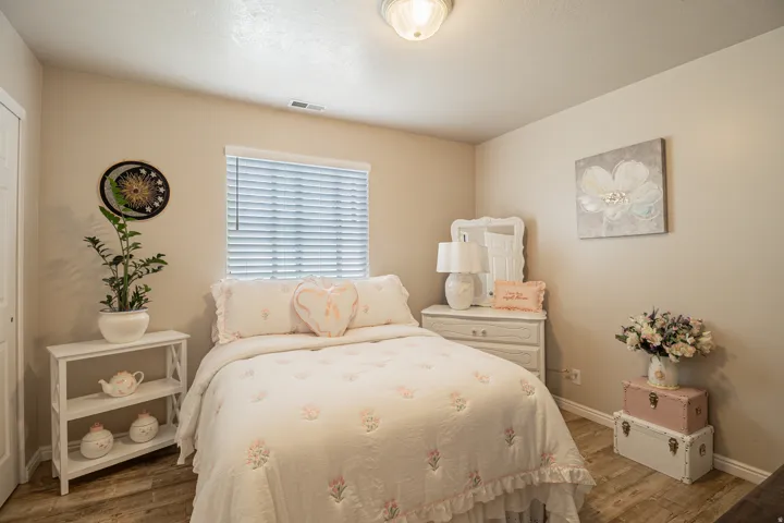 Neutral wall paint, wood-finish flooring, white window blinds, and overhead ceiling light fixture