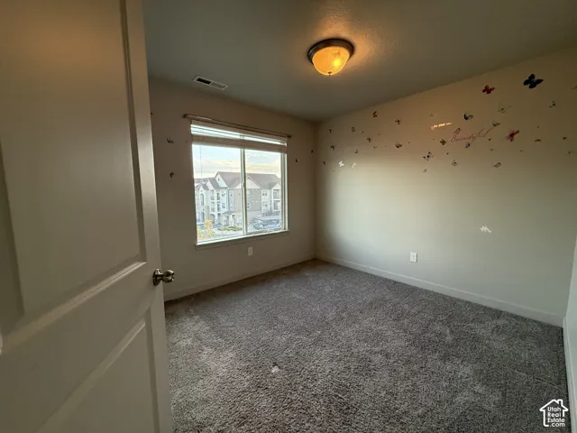 Carpeted room with a large window and a ceiling-mounted light fixture