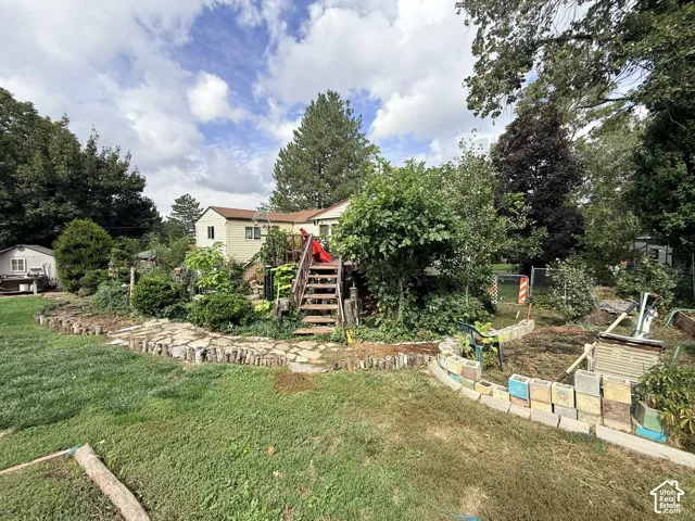 Rear exterior showcasing a multi-level deck with stairs, a stone-paved path, and a storage shed
