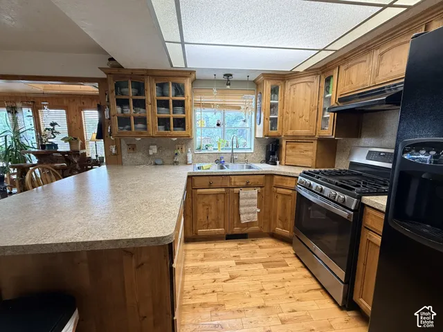 Kitchen featuring wood cabinetry, stainless steel range, and light-toned countertops