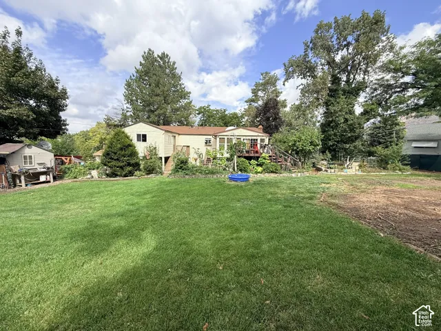 Expansive lawn area with a detached shed and mature trees