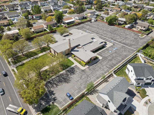 Expansive surface parking, extensive green space, mature trees, and a modern architectural design