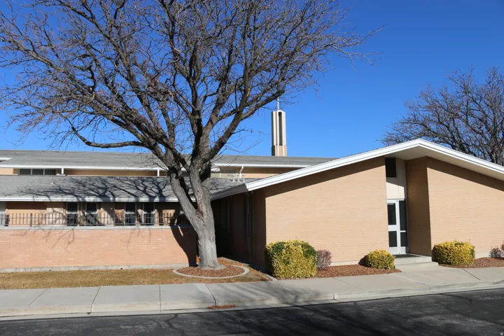Tan brick exterior with a gray sloped roof
