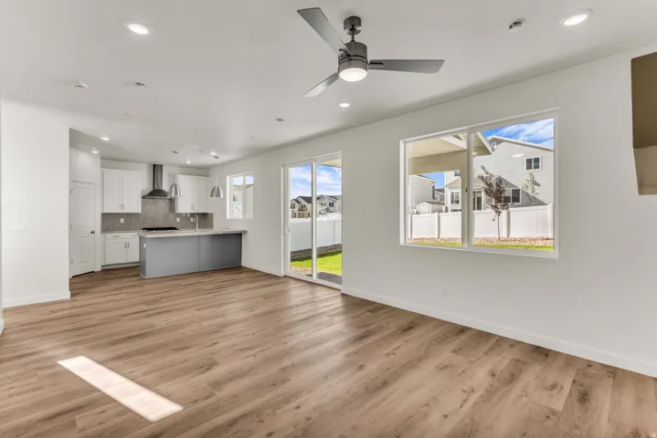 Open concept living space featuring wood-finish flooring, white walls, and recessed lighting