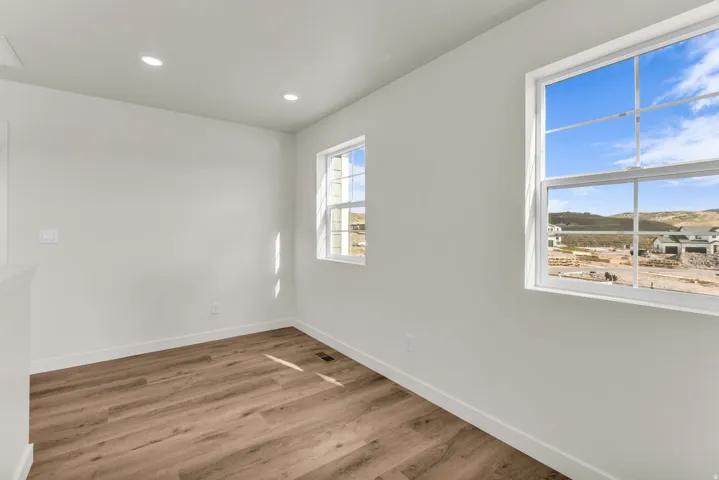 Bright interior with wood-finish flooring, recessed lighting, and two multi-pane windows