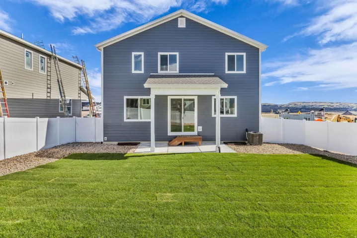 Two-story residence with blue siding, white trim, a covered patio, and a sliding glass door