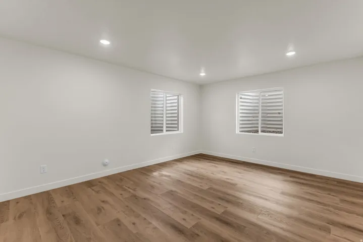 Recessed lighting, wood-finish flooring, and white walls