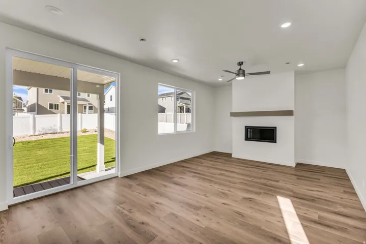 Recessed lighting, wood-finish flooring, ceiling fan, built-in fireplace, and sliding glass door