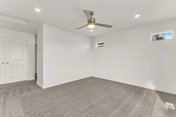 Neutral carpet flooring, recessed lighting, and a modern ceiling fan