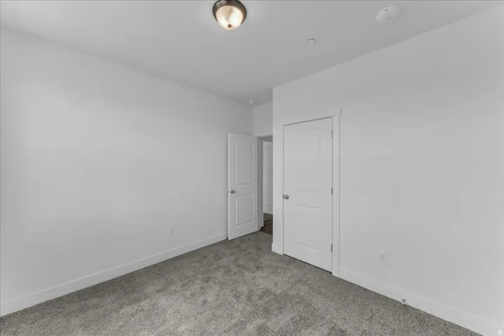 Neutral wall finishes, recessed lighting, and carpeted flooring