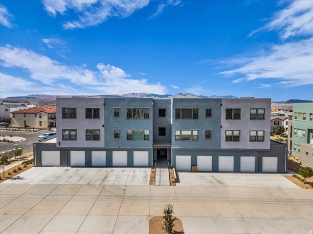 Modern multi-level building with individual garages and a neutral-toned exterior