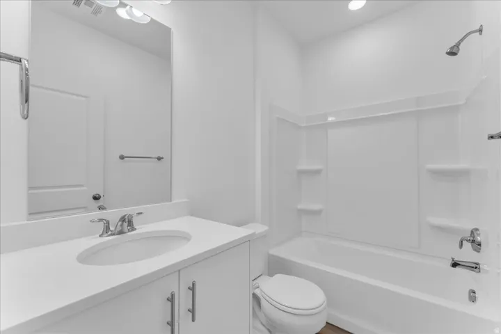 White vanity with integrated sink, chrome faucet, and under-cabinet storage