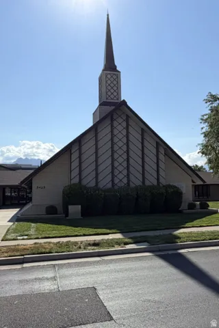Building exterior featuring a steeple, brick facade, and sloped roof