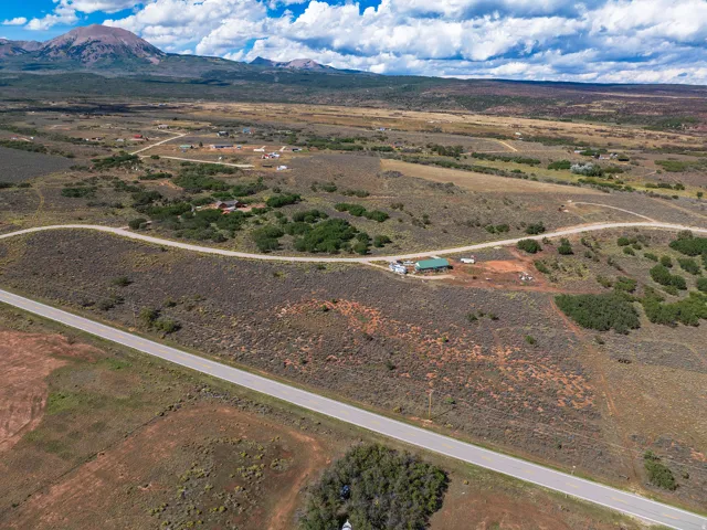 Expansive natural landscape featuring distant mountain ranges and a paved road