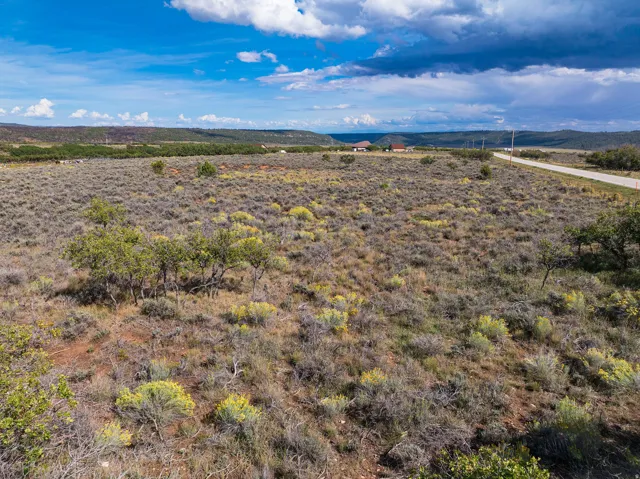 Expansive undeveloped land featuring natural vegetation and distant mountain ranges