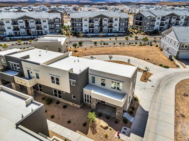 Modern architectural design with contrasting light and dark stucco finishes, stone accents, and flat rooflines