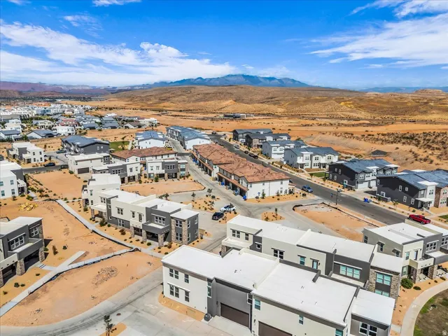 Contemporary residential development featuring diverse architectural styles, visible roadways, and expansive desert landscape