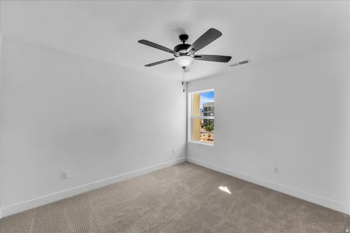 Carpeted flooring, single window, and a ceiling fan with integrated lighting