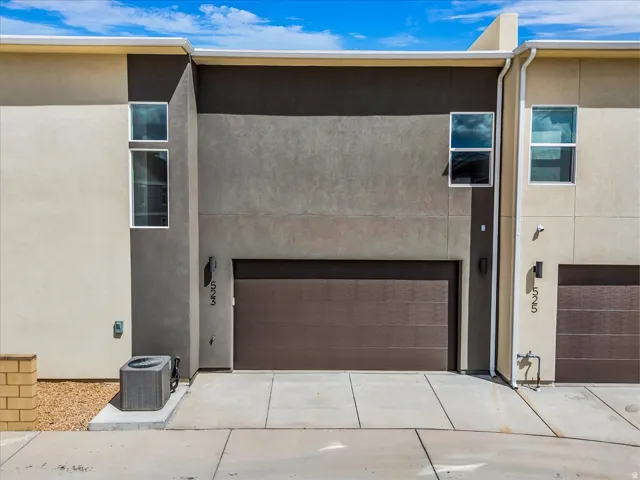 Contemporary exterior with multi-toned stucco, an integrated garage, and a concrete driveway