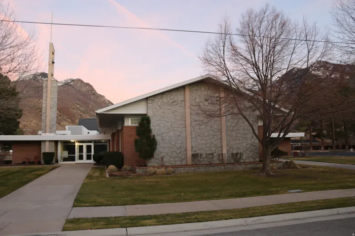 Brick and stone exterior with a prominent entrance, a tower element, and a pitched roofline
