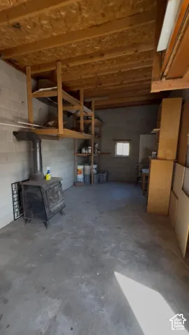 Concrete flooring, wood beam ceiling, block wall construction, built-in wood shelving, and a small window