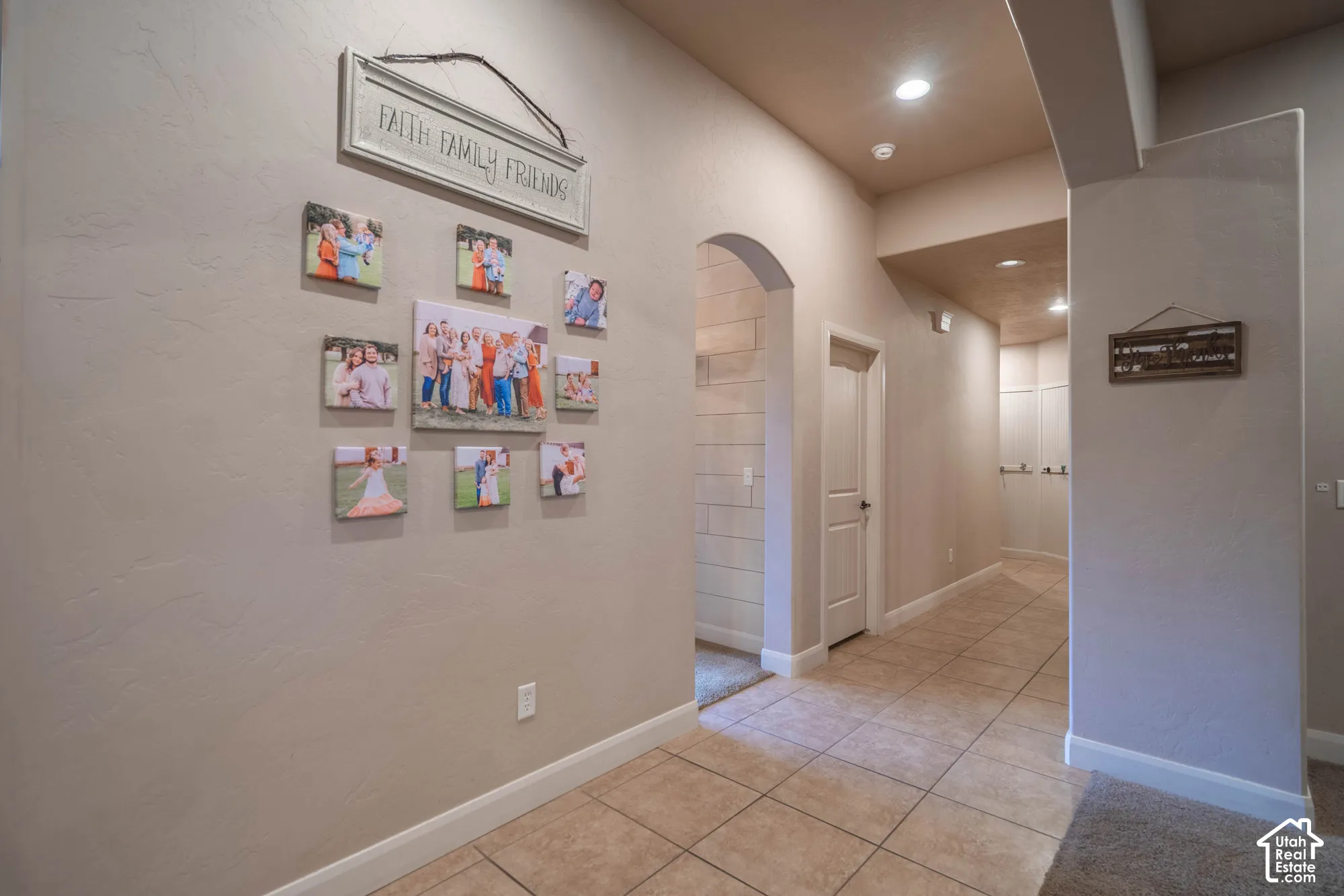 Hallway with recessed lighting, tile flooring, and arched entryway