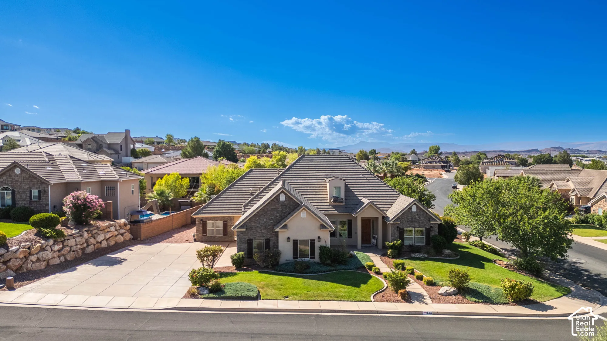 Stone and stucco exterior with a multi-gabled roof, featuring a dormer window and an inviting front entrance