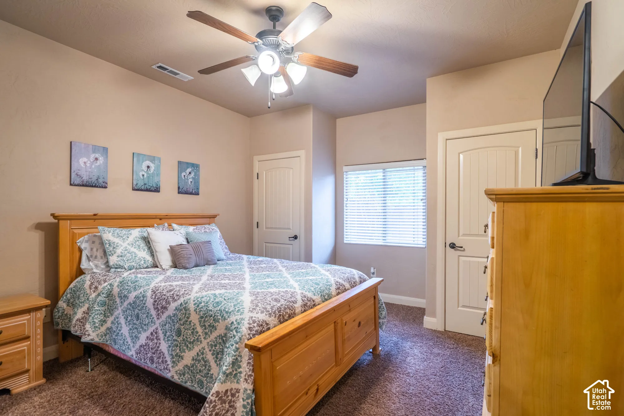 Neutral wall paint, ceiling fan with integrated lighting, window with horizontal blinds, textured carpeting, and paneled interior doors
