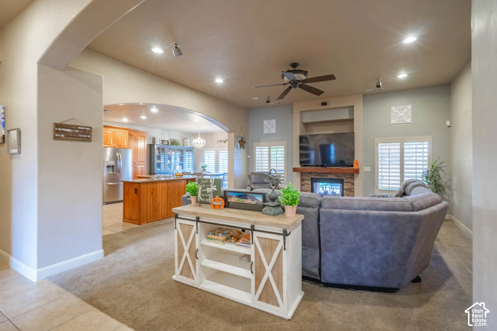 Arched entryway to the kitchen with wood cabinetry and a central island