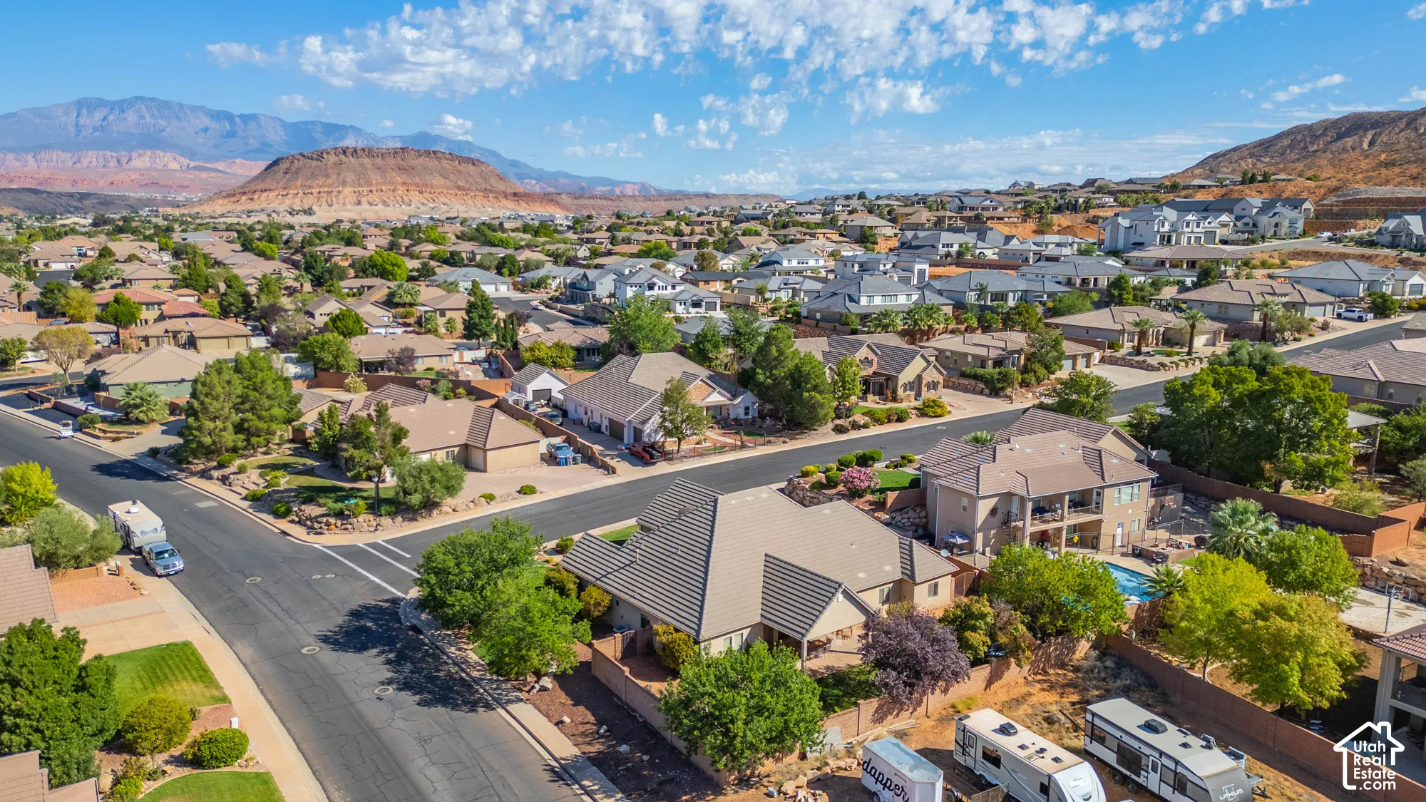 Expansive residential neighborhood with diverse architectural styles, mature landscaping, and an inground swimming pool