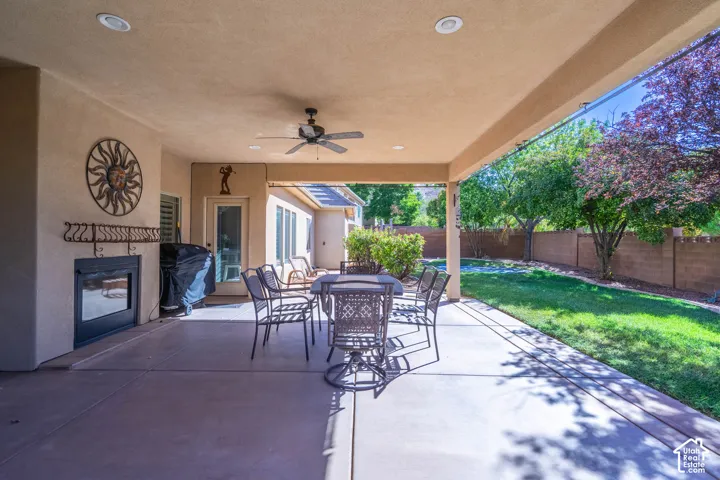 Covered patio with a built-in fireplace, ceiling fan, recessed lighting, and concrete flooring