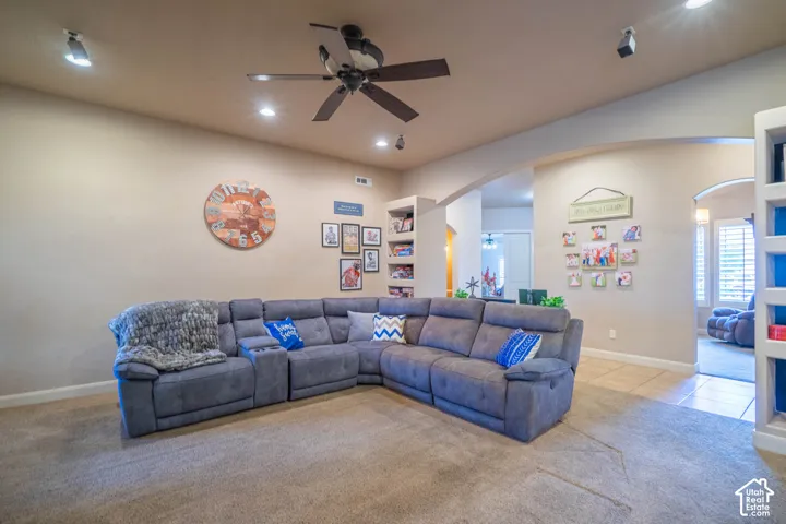 Recessed lighting, ceiling fan, arched doorways, and built-in shelving