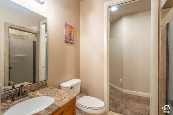 Bathroom vanity with a granite countertop, undermount sink, and bronze-finish faucet