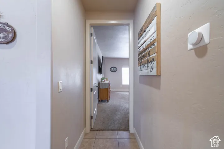 Tiled entryway flooring leading to a carpeted interior