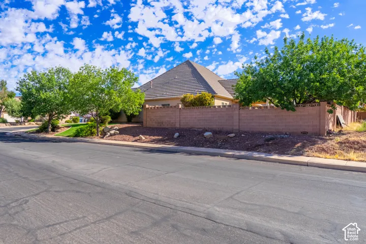Exterior featuring a tiled roof, stucco siding, and a brick privacy wall