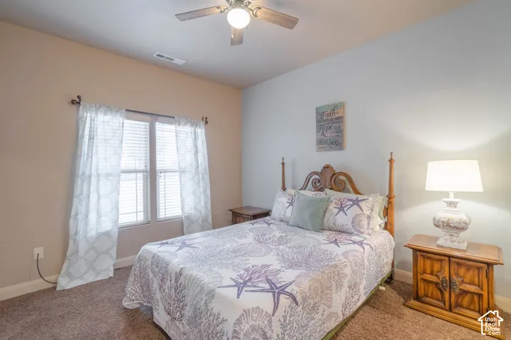 Carpeted flooring, window with blinds, ceiling fan, and painted walls