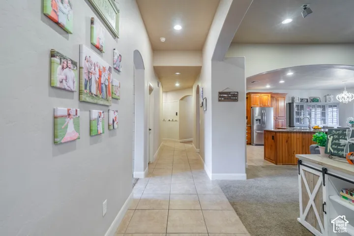 Hallway featuring arched doorways and recessed lighting