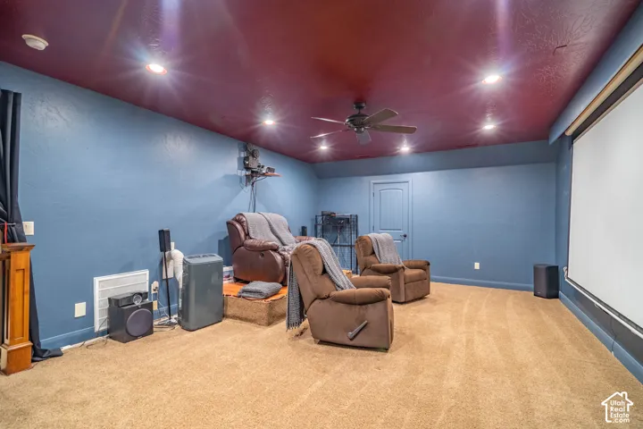 Recessed lighting and ceiling fan in a room with blue walls, a red ceiling, and carpet flooring