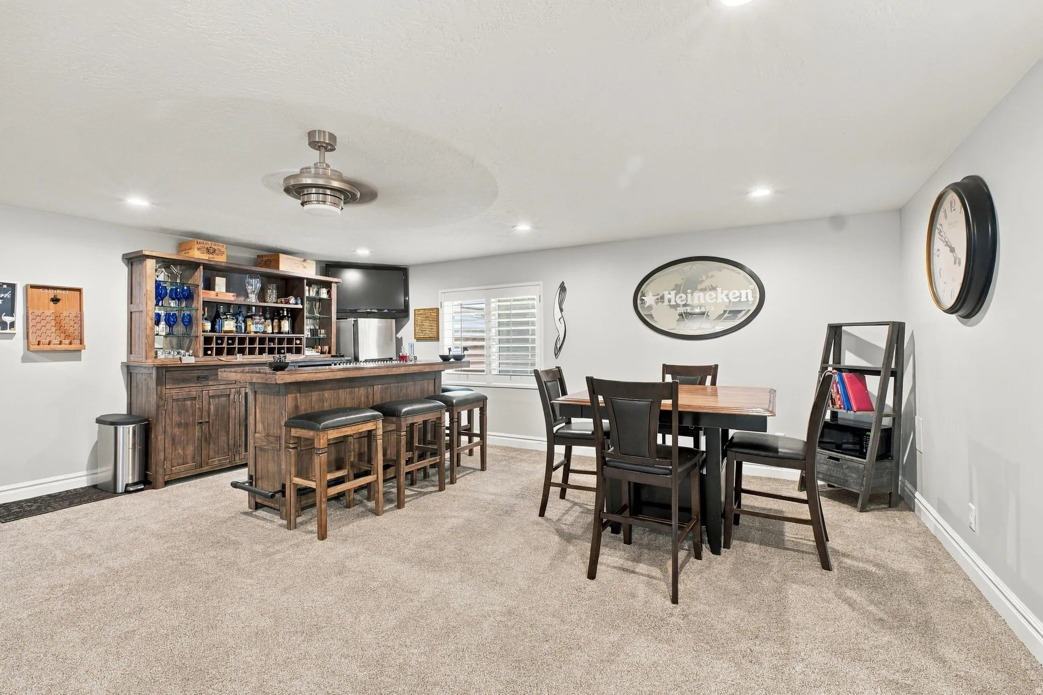 Built-in wet bar with wood cabinetry, recessed lighting, and a ceiling fan
