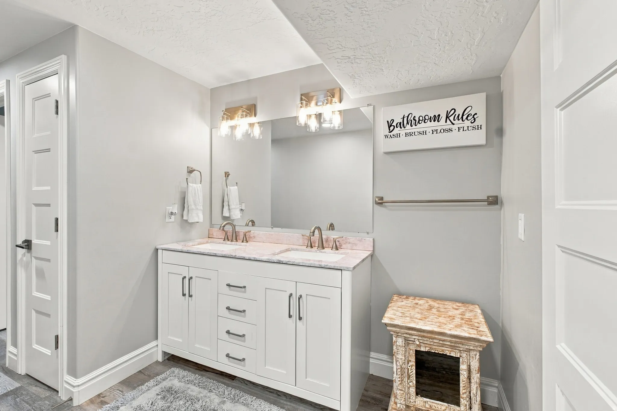 Double vanity with white cabinetry, dual sinks, and light-toned countertop